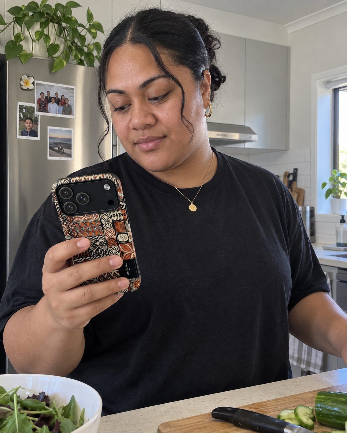 Tough Phone Case in the Elei print, held while sitting at a kitchen table at home.